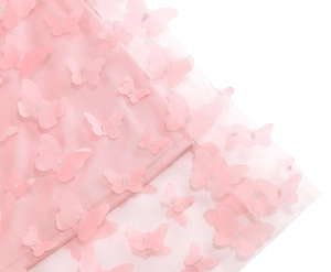 Dettaglio gonna in tulle rosa con applicazioni di farfalle 3D e tessuto a rete fine