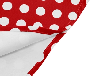 Dettaglio di un abito rosso a pois bianchi che mostra le cuciture e la trama del tessuto