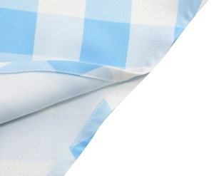 Détail de couture sur tissu à carreaux vichy bleu et blanc avec finitions soignées