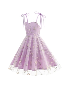 Détail de la broderie florale et du nœud sur la robe multicouche en tulle lavande