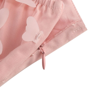 Close-up of pink mesh dress featuring 3D butterfly appliques and hidden zipper detail