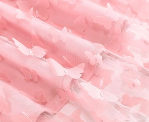Dettaglio del tessuto a rete rosa con applicazioni di farfalle 3D per gonne a trapezio