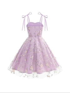 Détail d'une robe en tulle violet clair avec broderie florale et nœuds aux épaules