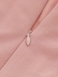 Detail view of pink V-neck dress featuring a seamless concealed zipper and premium matte fabric