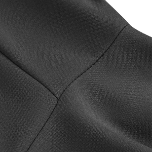 Gros plan détaillé montrant les coutures fines et la texture mate de la robe noire