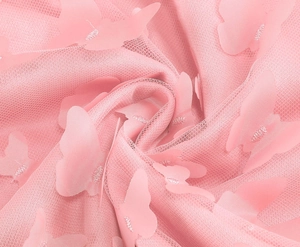 Dettaglio del tessuto a rete rosa con applicazioni di farfalle 3D e trama delicata