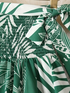 Détail du tissu froncé à imprimé tropical vert avec rubans noués sur les épaules