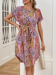 Detail of vibrant paisley print dress with V-neckline and adjustable waist tie