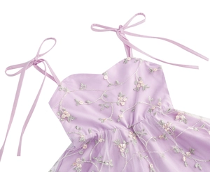 Détail de robe en tulle lavande pour fille avec broderie florale et nœuds aux épaules