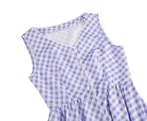 Close-up of V-neck dress with purple gingham pattern, white lace trim and heart buttons