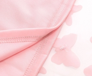 Dettaglio macro del ricamo a farfalla 3D su tulle rosa e tessuto a maglia fine