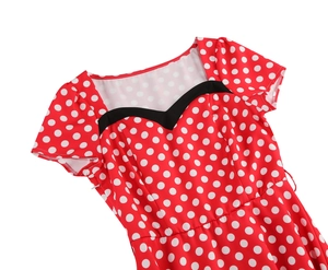 Close-up of vintage heart-shaped neckline with black trim on red polka dot dress