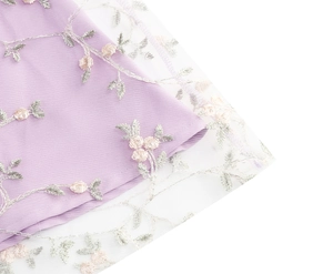 Détail macro d'une broderie florale exquise sur un tissu en tulle violet