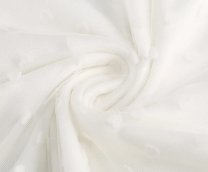 Detail view of white mesh fabric with polka dot flocking and delicate texture