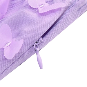Detail of purple mesh dress showing a 3D butterfly appliqué and hidden zipper closure