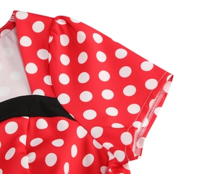 Detail view of red and white polka dot dress with V-neck and black contrast trim