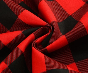 Dettaglio del tessuto a quadri rosso e nero con morbida trama a saia e drappeggio elegante