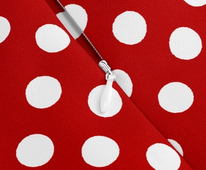 Dettaglio del tessuto rosso a pois con cerniera invisibile bianca e cursore a goccia sottile