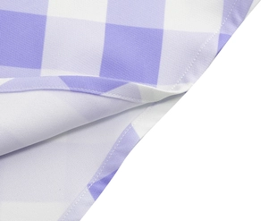 Gros plan sur l'ourlet piqué et la texture du tissu vichy violet de la robe d'été