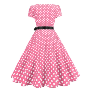 Macro detail of pink polka dot dress showing fabric texture and black waist belt buckle