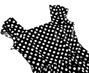 Détail d'une robe rétro à pois noirs et blancs avec décolleté carré et larges bretelles