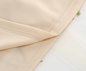 Detailed close-up of embroidery and neat stitching on beige vintage mesh party dress