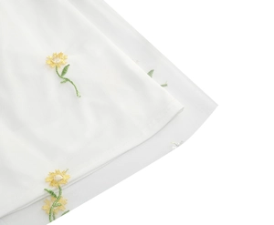 Close-up of white mesh dress with yellow sunflower embroidery and delicate floral details