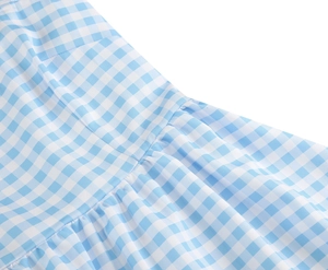 Macro detail of pink gingham fabric texture and ruffled stitching on the maxi dress