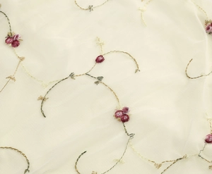 Nahaufnahme der eleganten Blumenstickerei auf Netzstoff mit rosa Blüten und Goldfaden