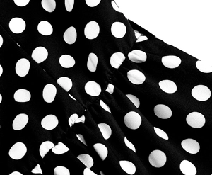 Vue macro détaillée du tissu noir à pois montrant les coutures fines et les plis de taille