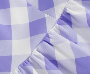 Détail du tissu vichy lavande avec coutures à volants sur une robe longue d'été