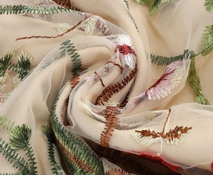 Macro detail showing multi-color floral embroidery on beige mesh tulle evening dress fabric