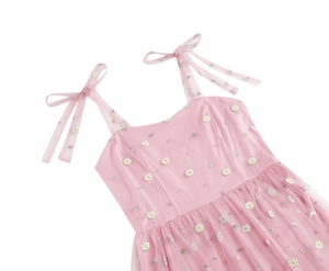 Detailed close-up of pink tulle dress featuring white daisy floral embroidery and bow straps