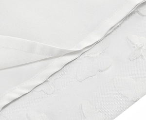 Detail of white mesh fabric with elegant butterfly embroidery on the dress hemline