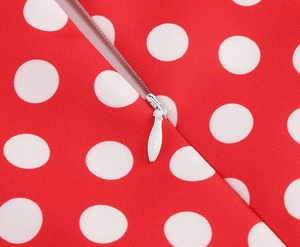 Détail d'une robe à pois rouges avec fermeture éclair invisible blanche et tirette