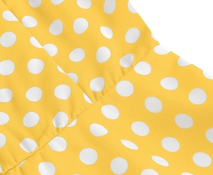 Dettaglio macro del tessuto giallo a pois bianchi con cuciture precise e rifinite