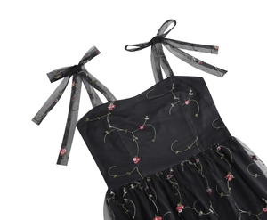 Detaillierte Stickerei mit rosa Blumen und Netzbogen-Trägern auf schwarzem Kleid