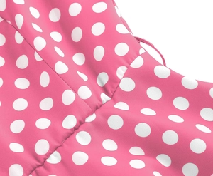 Macro shot of pink fabric with white polka dots showing smooth seams and fine stitching