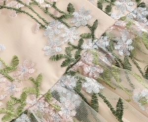Close-up of intricate floral embroidery on vintage mesh dress with champagne gold fabric