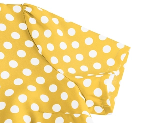 Vista macro dettagliata della manica del vestito giallo a pois con trama in rete fine