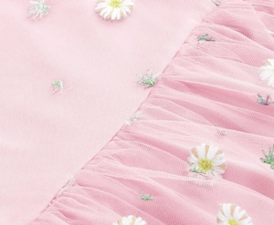 Macro shot of pink mesh fabric with detailed white daisy floral embroidery and leaf textures