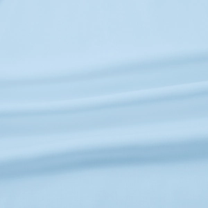 Close-up of light blue textured fabric detail showing soft drape and fine weave texture