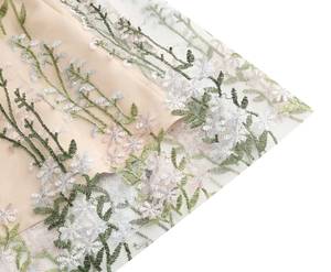 Close-up of intricate floral embroidery on delicate tulle layers of this evening dress