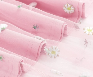 Close-up of pink mesh tulle fabric with multi-color floral embroidery and layered pleats