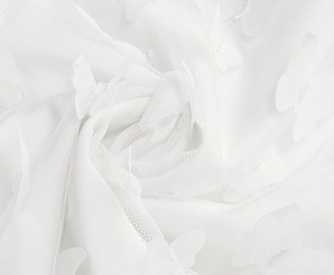 Detail view of delicate white mesh fabric featuring 3D butterfly appliqué ornaments
