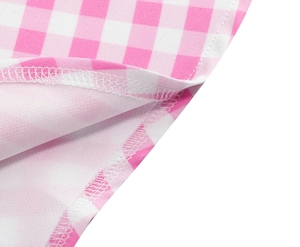 Detail of sewing and edge stitching on pink gingham V-neck dress fabric texture