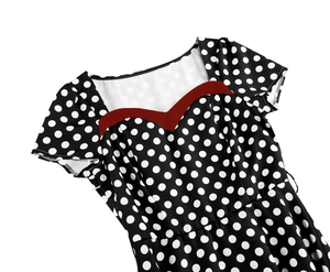 Detail of the sweetheart neckline with red trim on a black polka dot retro dress
