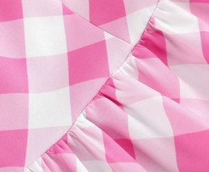 Détail du tissu Vichy rose et blanc montrant les coutures fines et la texture volantée