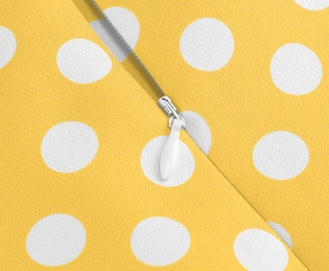 Dettaglio dell'abito giallo a pois con cerniera invisibile e texture del tessuto pregiato