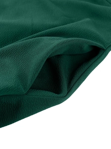 Detailed macro view of a hidden side pocket on dark green crepe texture evening dress